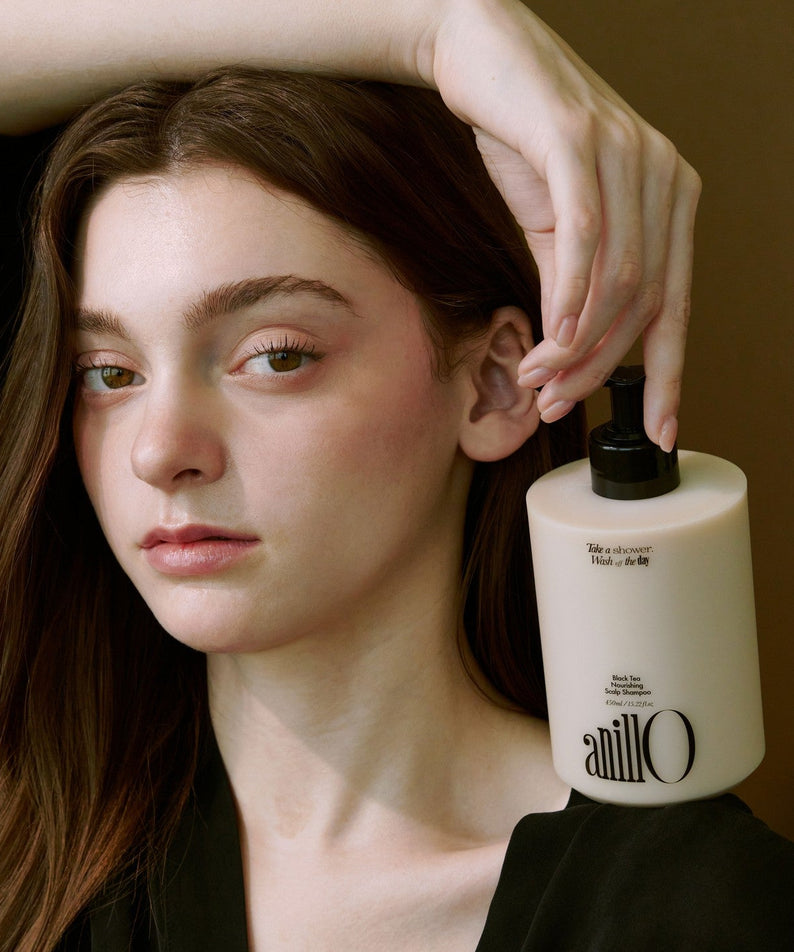 ANILLO Black Tea Nourishing Scalp Shampoo 450ml : femme touchant ses cheveux, flacon présenté, contexte spa beauté.