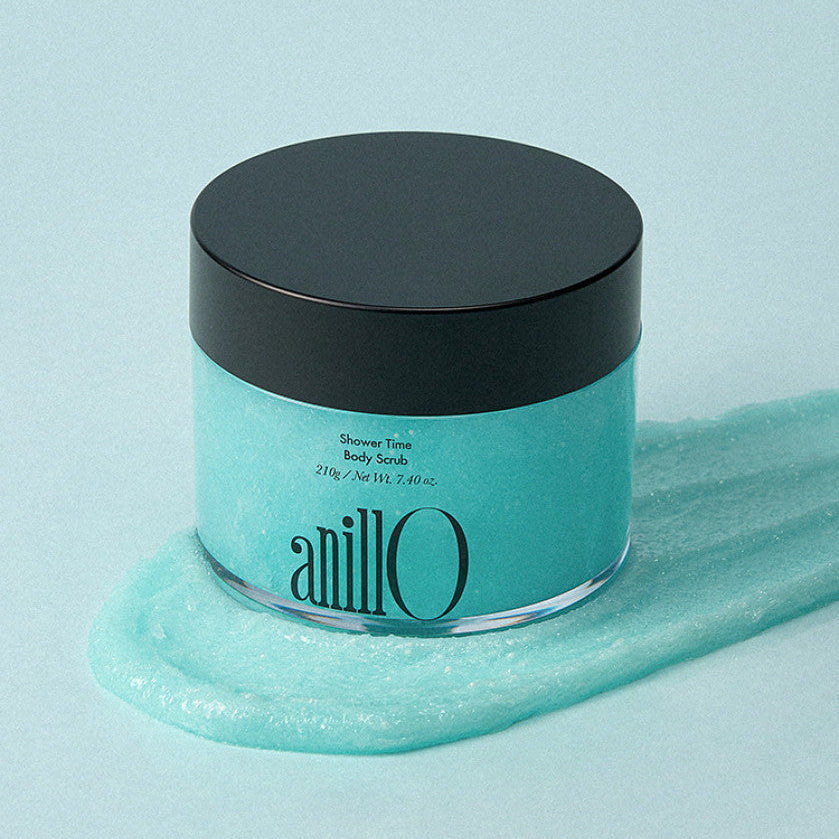 ANILLO Shower Time Body Scrub 210g : pot bleu noir sur gel douche, ambiance salle de bain, marque ANILLO en gros plan.