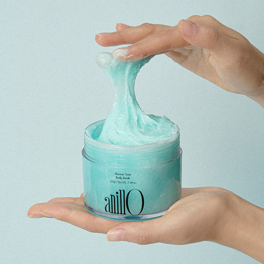 ANILLO Shower Time Body Scrub 210g : pot de gommage bleu en mains, texture sous la douche, marque ANILLO