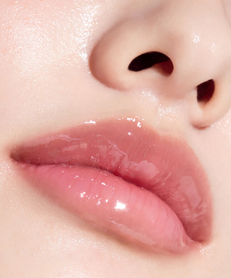 Gros plan sur les lèvres brillantes avec ANUA PDRN Lip Serum, marque ANUA, texture de sérum sur la peau.