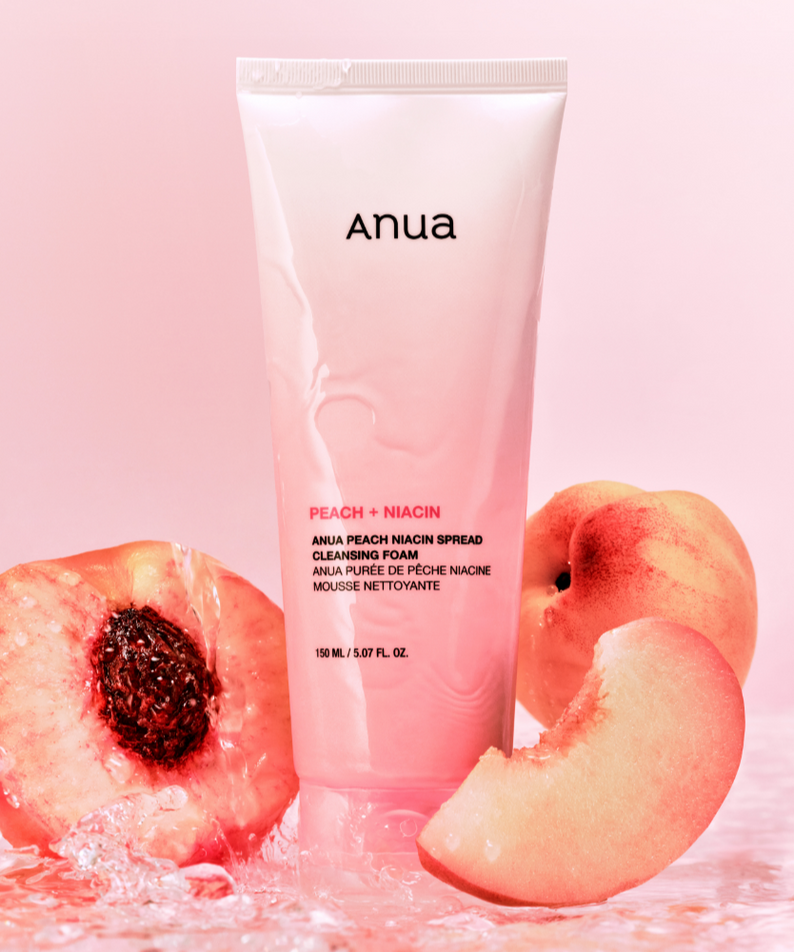 Crème nettoyante ANUA Peach Niacin Spread Cleansing Foam 150ml avec des morceaux de pêche fraîchement coupés.