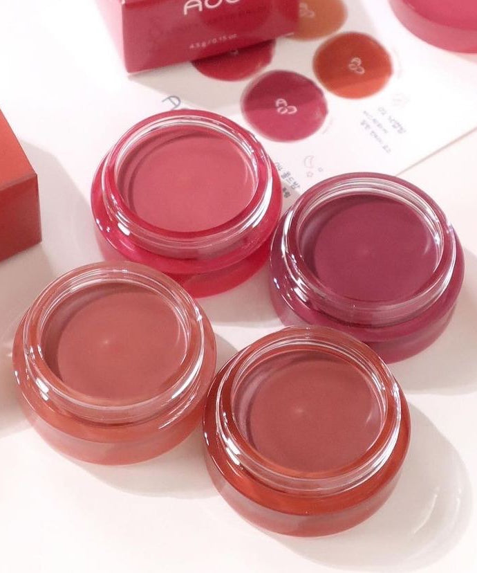 AOU Floofy Matte Balm de la marque AOU, baumes mats roses en pots sur fond blanc, packshot maquillage.