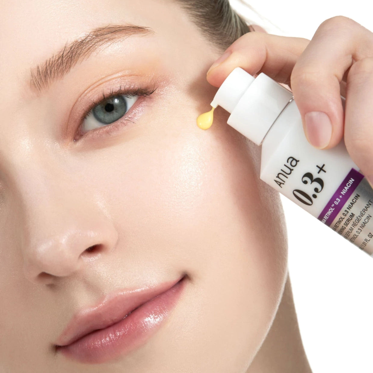 Visage en gros plan avec une pipette appliquant ANUA Retinol 0.3 Niacin Renewing Serum, marque ANUA, peau hydratée