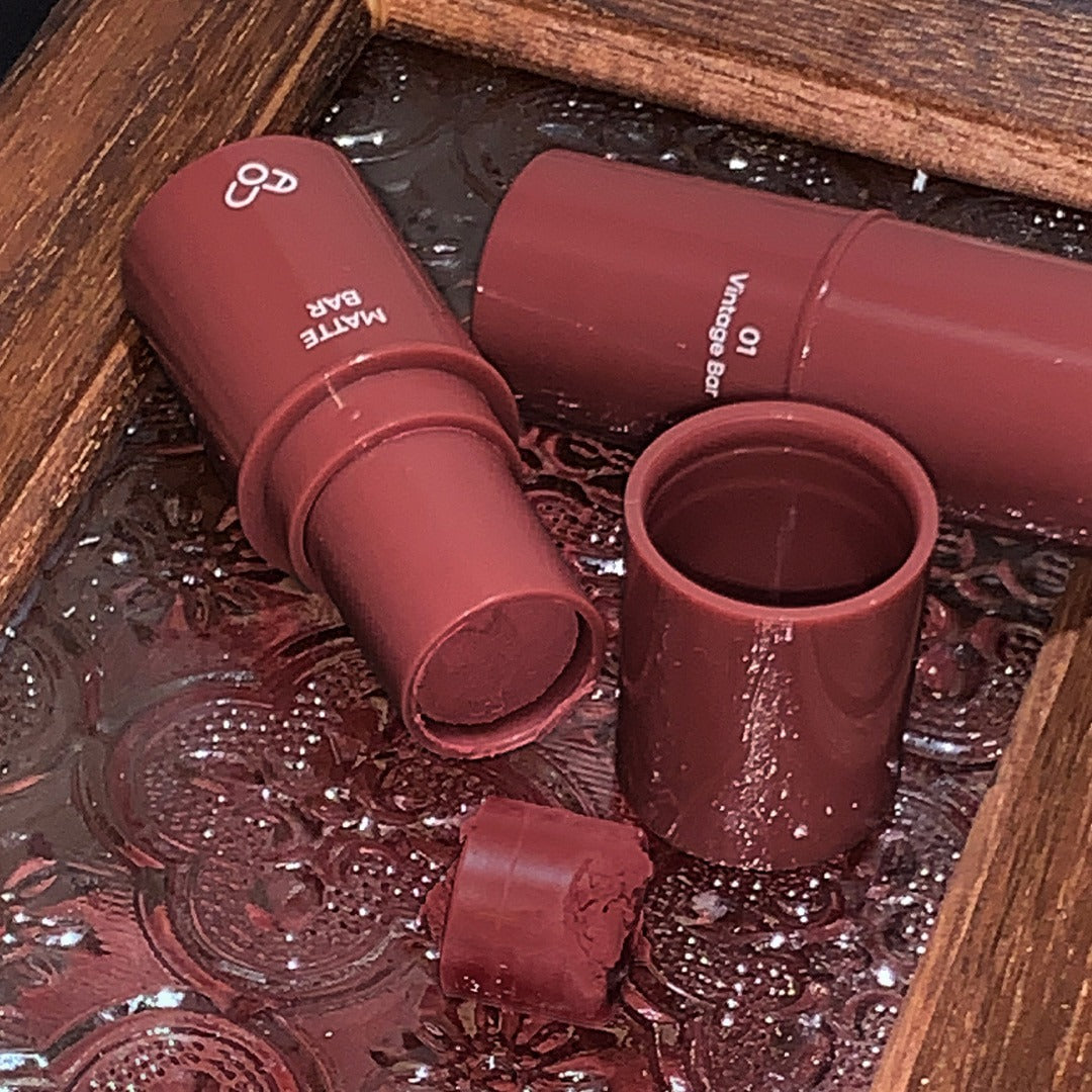 AOU Matte Bar de la marque AOU, sur fond bois, texture mate et ambiance sombre, rendu en gros plan.