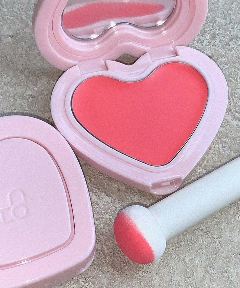 Blush crème doux AOU en forme de cœur, couleur rose vif, avec applicateur. Améliorez votre éclat avec AOU Soft Cream Blush.