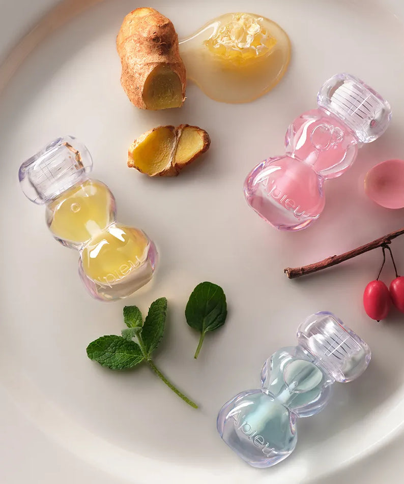 A'PIEU Jelly Honey Lip Oil 4g, marque A'PIEU : huile à lèvres en flacons roses et jaunes sur fond blanc, ambiance douceur
