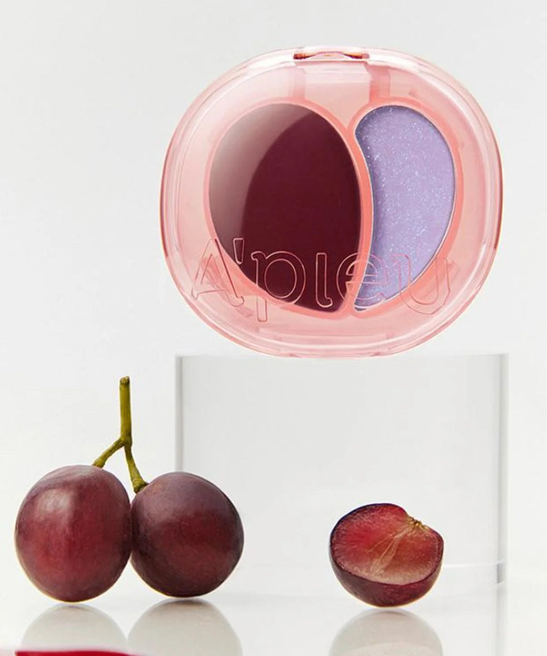 A'PIEU Juicy Pang Mood Blending Lip & Cheek Balm, packaging rose et duo de teintes sur fond blanc, raisins et prune.