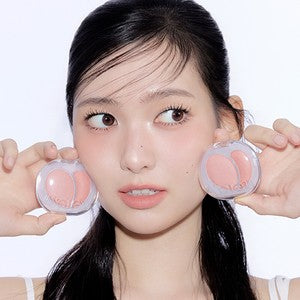 A'PIEU Mood Blending Jelly Cheek Balm : jeune femme tient le baume-jelly rose, fond clair, branding A'PIEU.