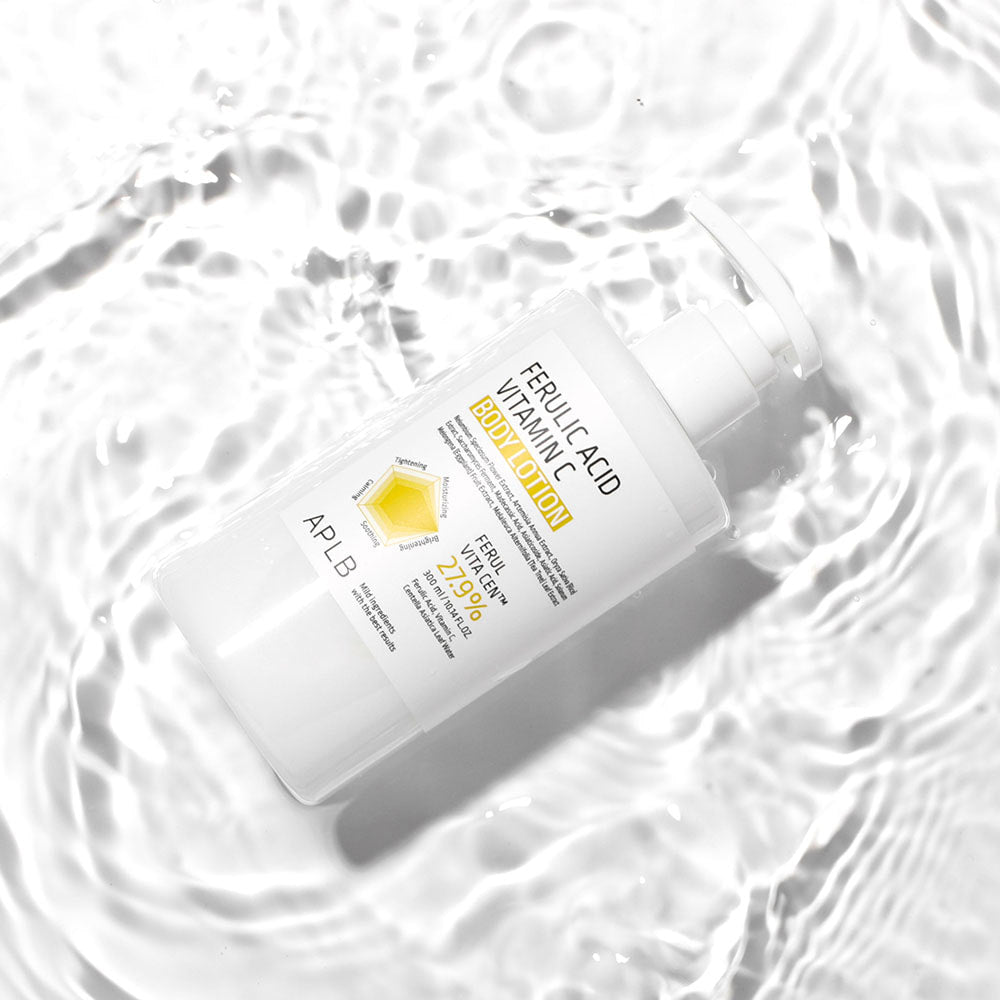 APL B Ferulic Acid Vitamin C Body Lotion 300ml, flacon blanc APLB sur tissu froissé blanc, ambiance soin beauté