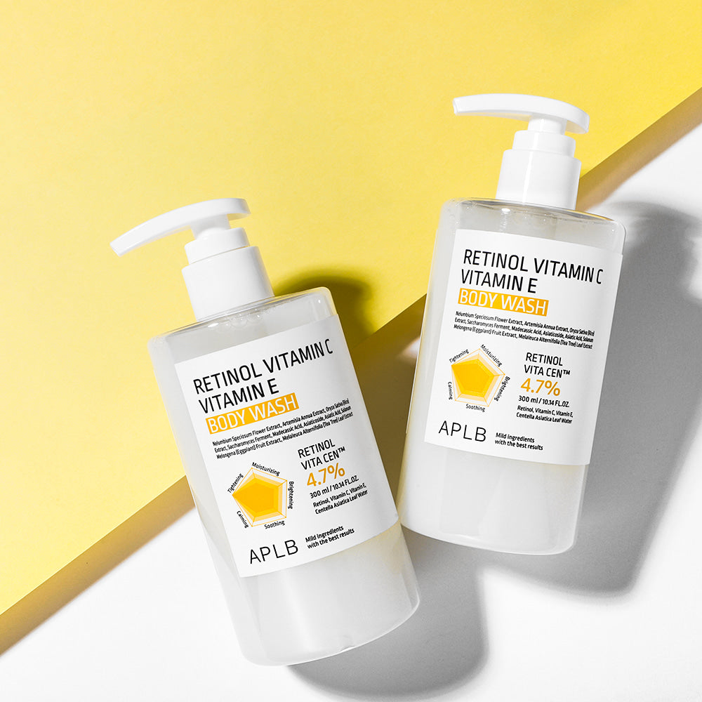 Décris l'image en français : APLB Retinol Vitamin C Vitamin E Body Wash 300ml, 2 flacons sur fond jaune.