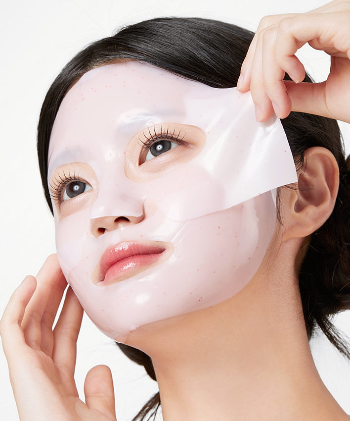 APRILSKIN TXA Niacinamide Collagen 99 Capsule Gel Mask 4 Sheets : femme applique un masque gel sur le visage, mains visibles.