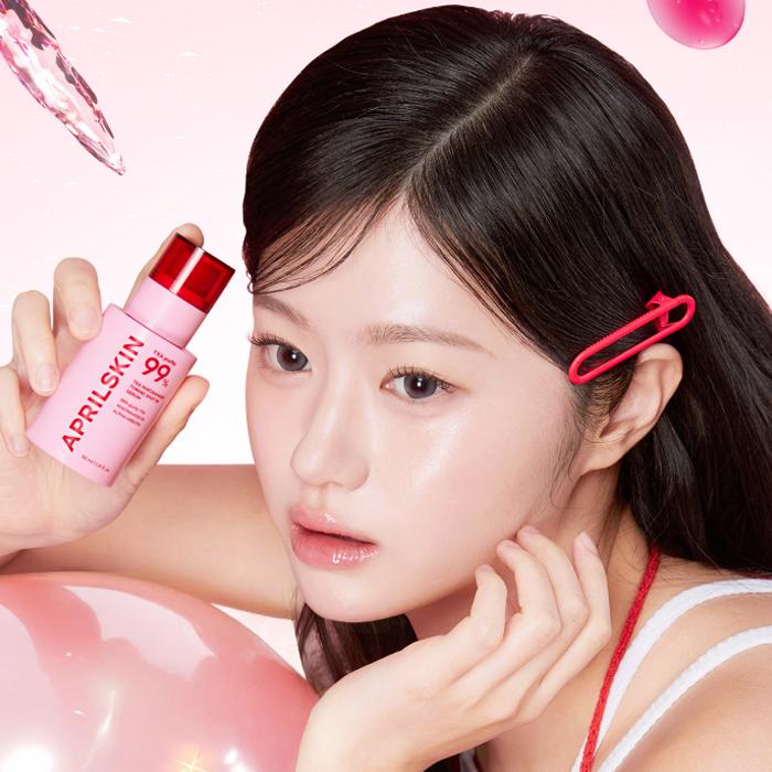 APRILSKIN TXA Niacinamide Toning Shot 99 Serum 30ml, flacon et femme avec accessoire, contexte soin beauté rose