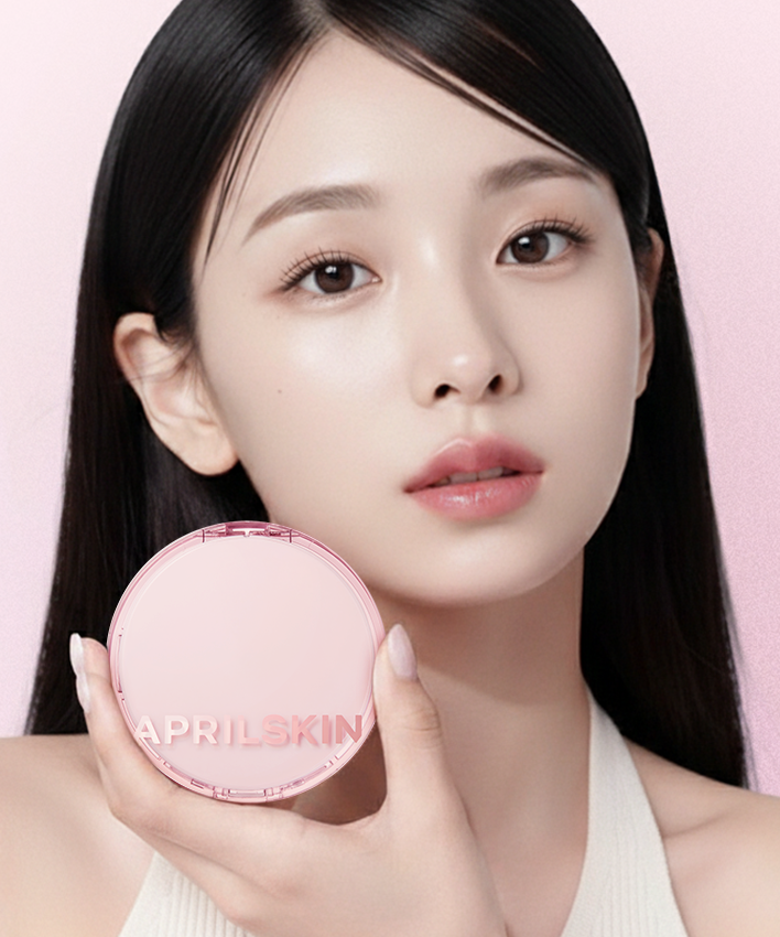 APRILSKIN Hero Cushion + Refill : jeune femme tient le boîtier sur fond rose, maquillage naturel APRILSKIN en gros plan.