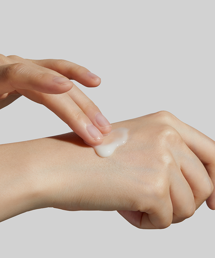 APRILSKIN Carrotene Clarifying Serum 30ml, APRIL SKIN : sérum clarifiant appliqué sur la peau, goutte sur main.