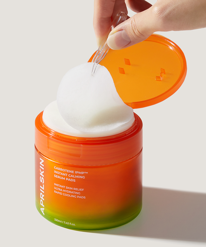 APRILSKIN Carrotene IPMP Inatant Calming Serum Pad, marque APRIL SKIN : pad sur pot orange, usage apaisant sur main