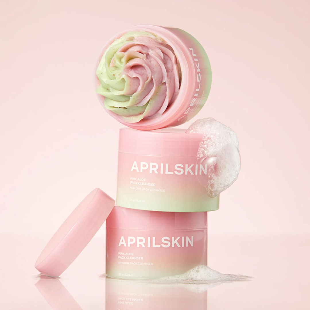 Décris l'image en français : APRILSKIN Pink Aloe Pack Cleanser, bouteille rose et verte sur fond pastel, marque APRILSKIN.