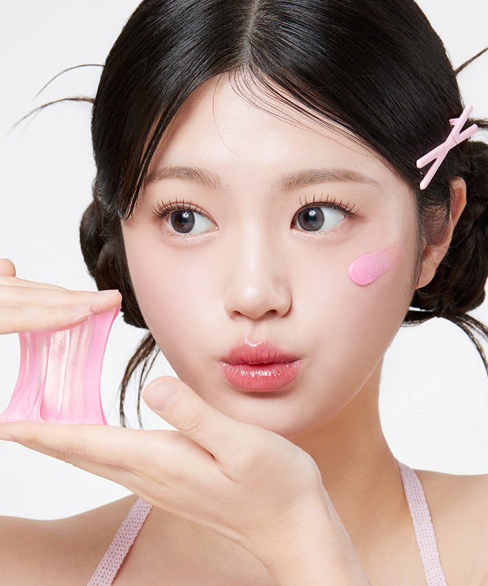 Femme utilisant un masque rose sur le visage, produit de soin de la peau pour la beauté et l'hydratation.