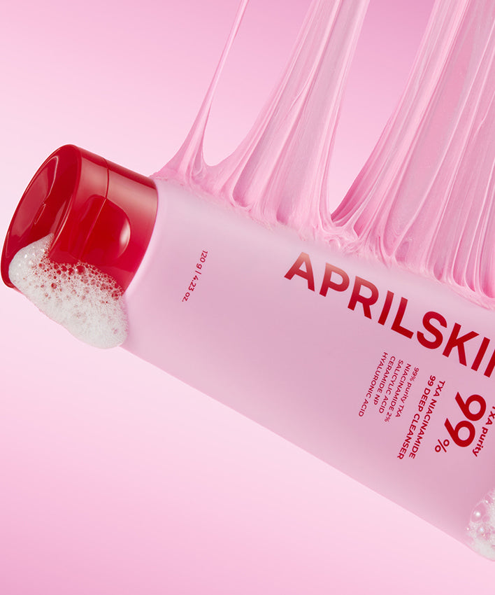 APRILSKIN TXA Niacinamide 99 Deep Cleanser 120g sur fond rose avec mousse.