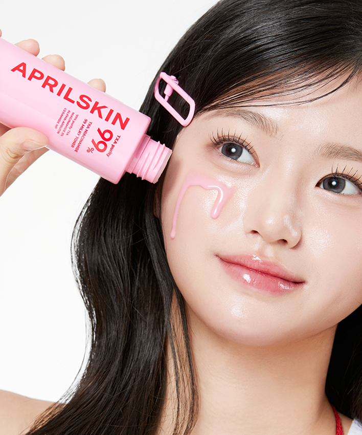 Jeune femme appliquant APRILSKIN TXA Niacinamide 99 Milky Toner 150ml sur son visage pour une peau éclatante.