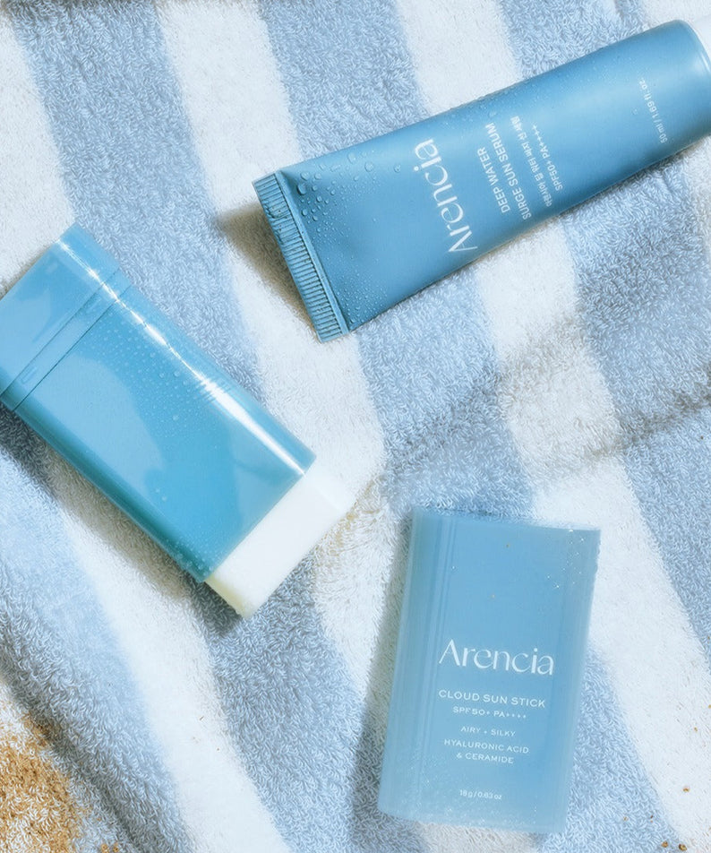 ARENCIA Cloud Sun Stick 18g de la marque ARENCIA sur serviette bleue, emballage et tube visibles, ambiance spa.