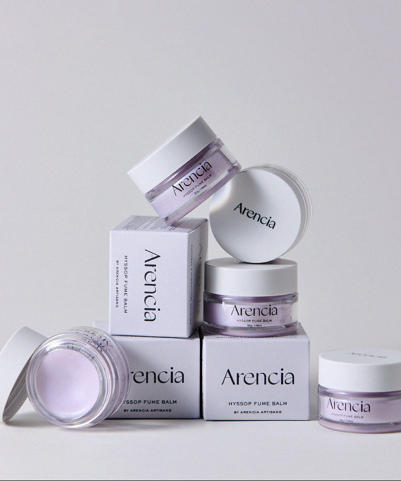 Boîtes et pots de ARENCIA Hyssop Fume Balm 30g empilés artistiquement.