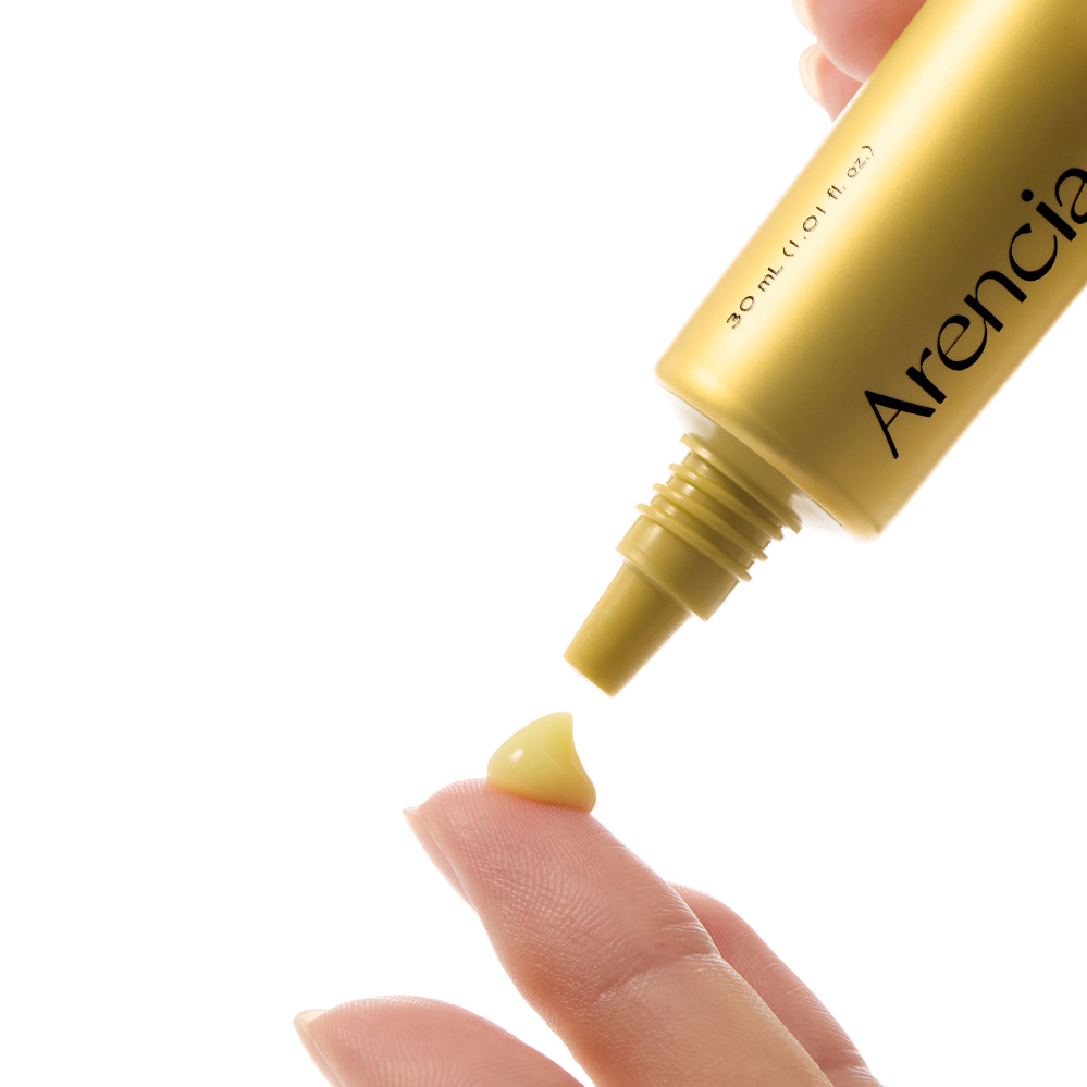 ARENCIA Retin-A Booster Shot 30ml, marque Are ncia : flacon doré appliqué sur peau, geste de soin, fond clair.