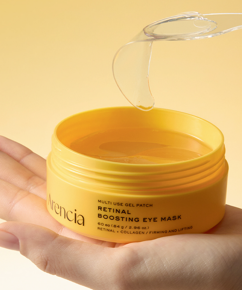 ARENCIA Retin-A Boosting Eye Mask 60ea : pot de masques pour le contour des yeux, main tenant le produit, fond beige.