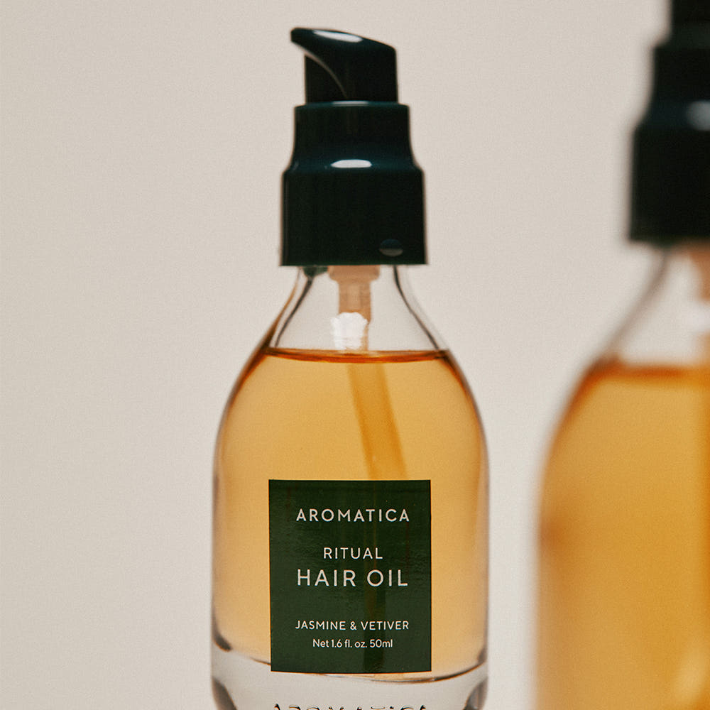 AROMATICA Ritual Jasmine & Vetiver Hair Oil 50ml, flacon ambré sur fond clair, photo produit en gros plan.