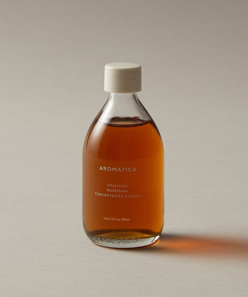 AROMATICA Vitalizing Rosemary Concentrated Essence 200ml, bouteille ambrée sur fond clair, essence à la main, style photo produit