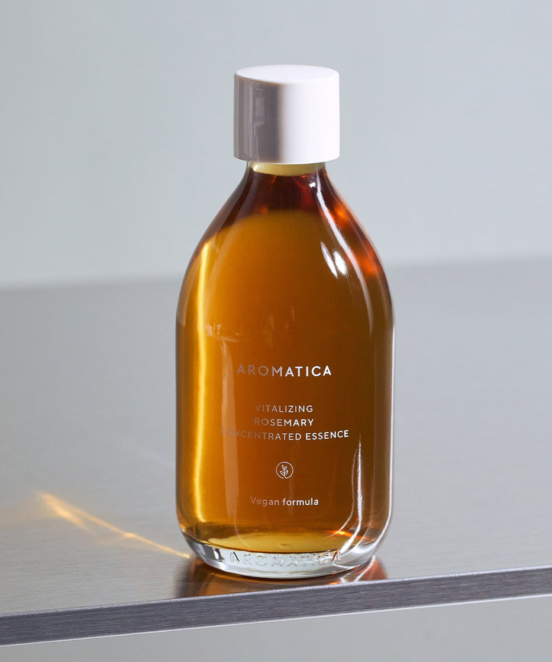 AROMATICA Vitalizing Rosemary Concentrated Essence 200ml, flacon ambré sur table grise, fond clair minimaliste, marque AROMATICA