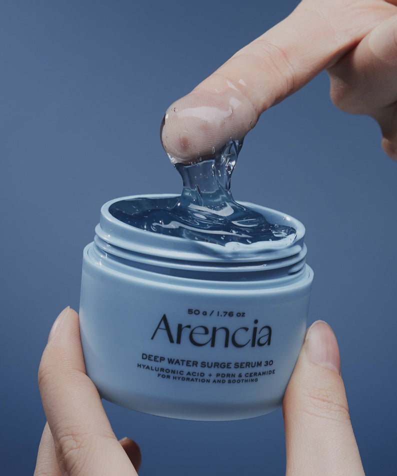 Sérum hydratant ARENCIA Deep Water Surge Serum 30 50g avec doigt prélevant le gel. Skincare visage pour une peau nourrie et hydratée.