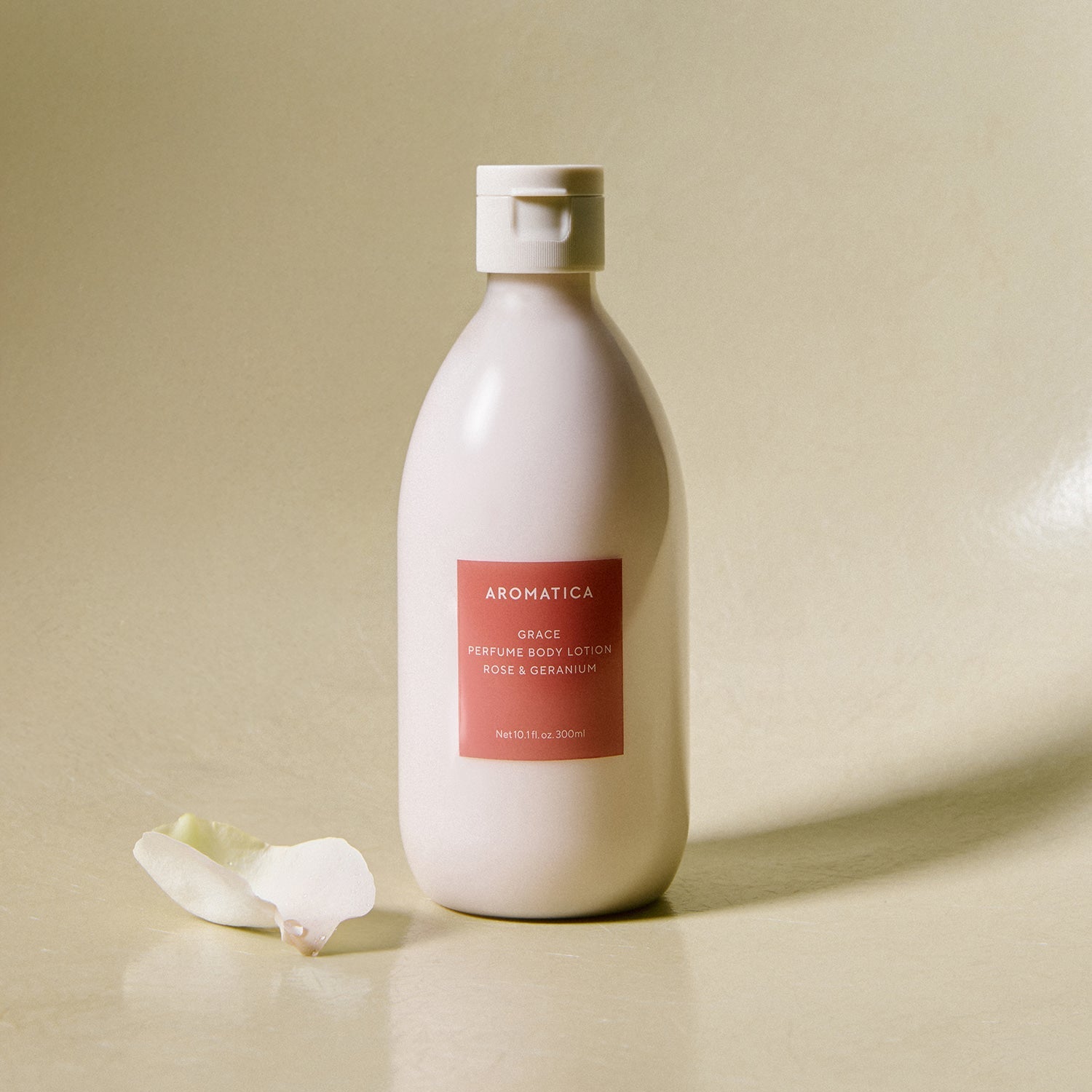 AROMATICA Grace Perfume Body Lotion Rose & Geranium 300ML de la marque AROMATICA, flacon crème sur fond beige, fleurs.