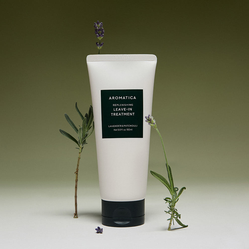 AROMATICA Replenishing Leave-In Treatment Lavender & Patchouli 150ML en tube blanc avec lavande, sur fond vert.