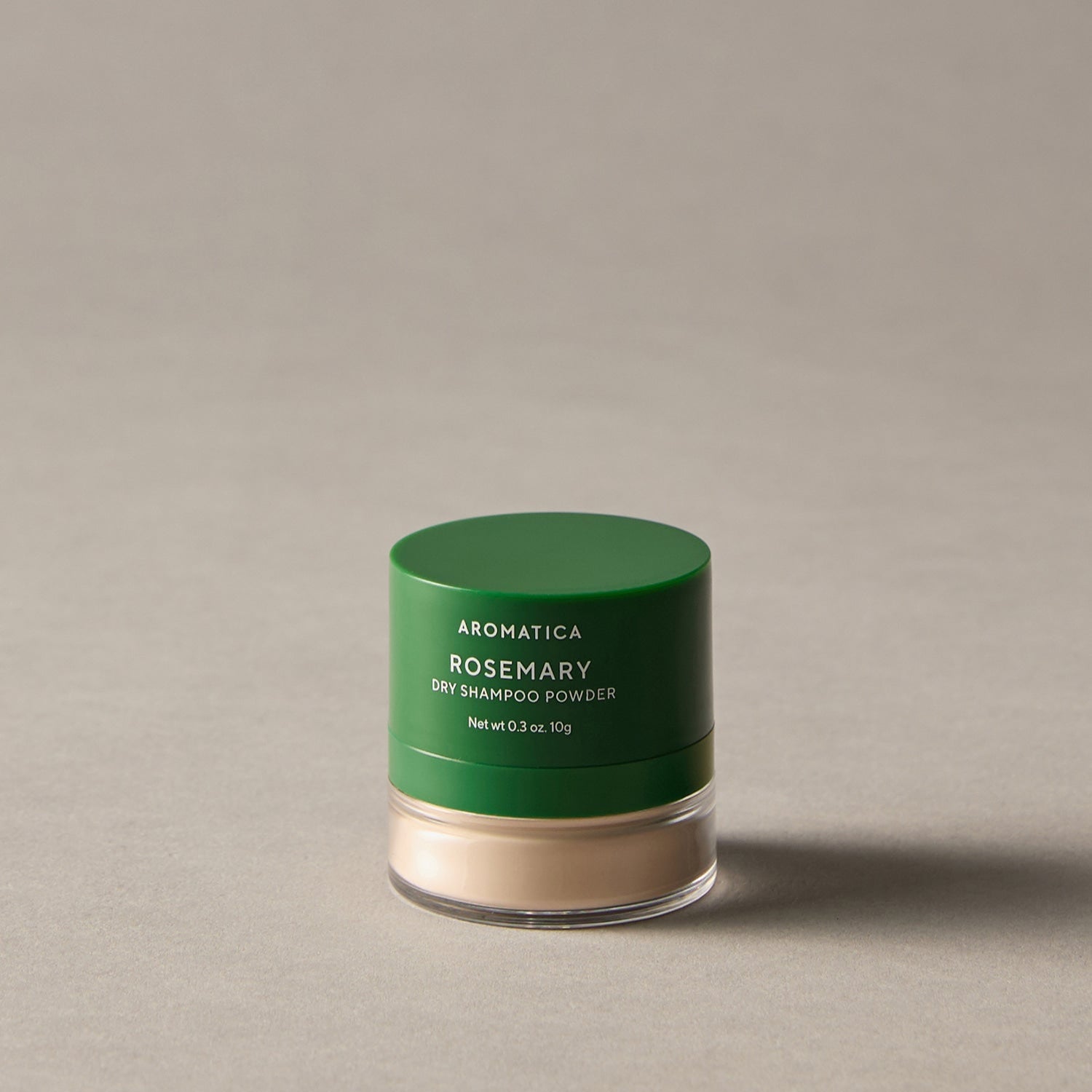 AROMATICA Rosemary Dry Shampoo Powder 10g de la marque AROMATICA, pot vert sur fond beige, produit cosmétique.