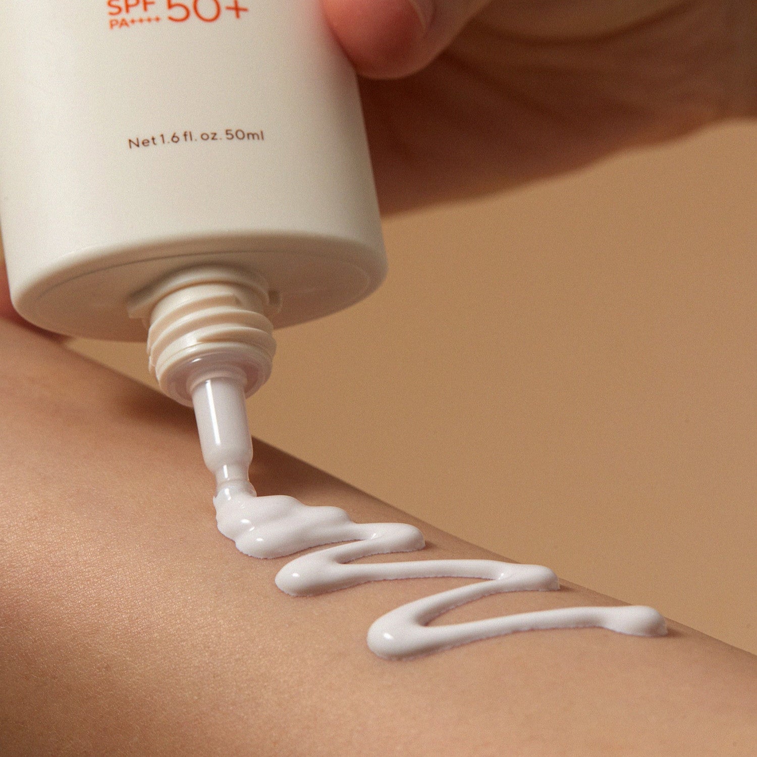 AROMATICA Vitalizing Rosemary Moisture Barrier Sunscreen 50ML, tube SPF50+ déposant une crème sur peau, gros plan.