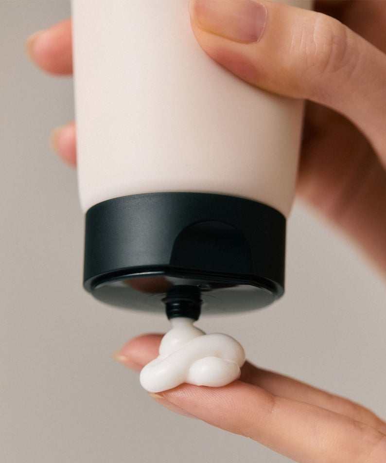 Personne appliquant l'AROMATICA Replenishing Leave-In Treatment Lavender & Patchouli 150ML sur les doigts, hydratation et soin.