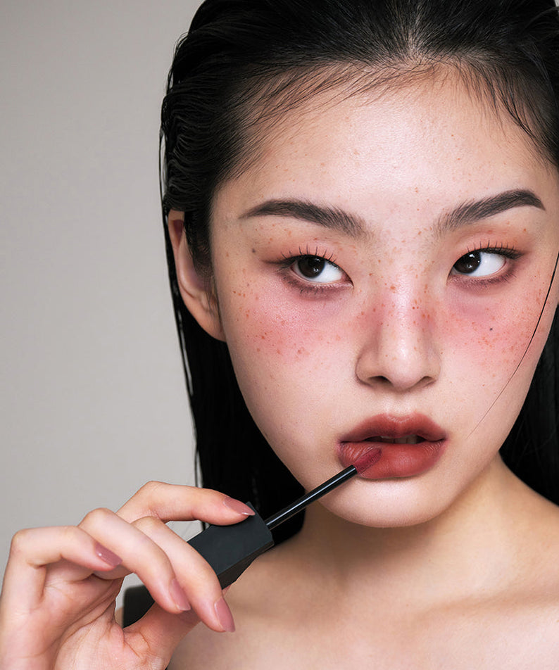 Jeune femme utilisant ARTESINSA Silky Blur Tints pour des lèvres lisses et sophistiquées. Rouge à lèvres séduisant pour un look élégant.