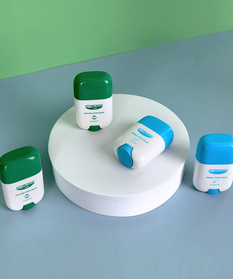 Photo de plusieurs sticks ATOMANDE Phyton Stick Balm 16.5g 1ea posés sur une surface avec des couleurs vives, soins de la peau hydratant.