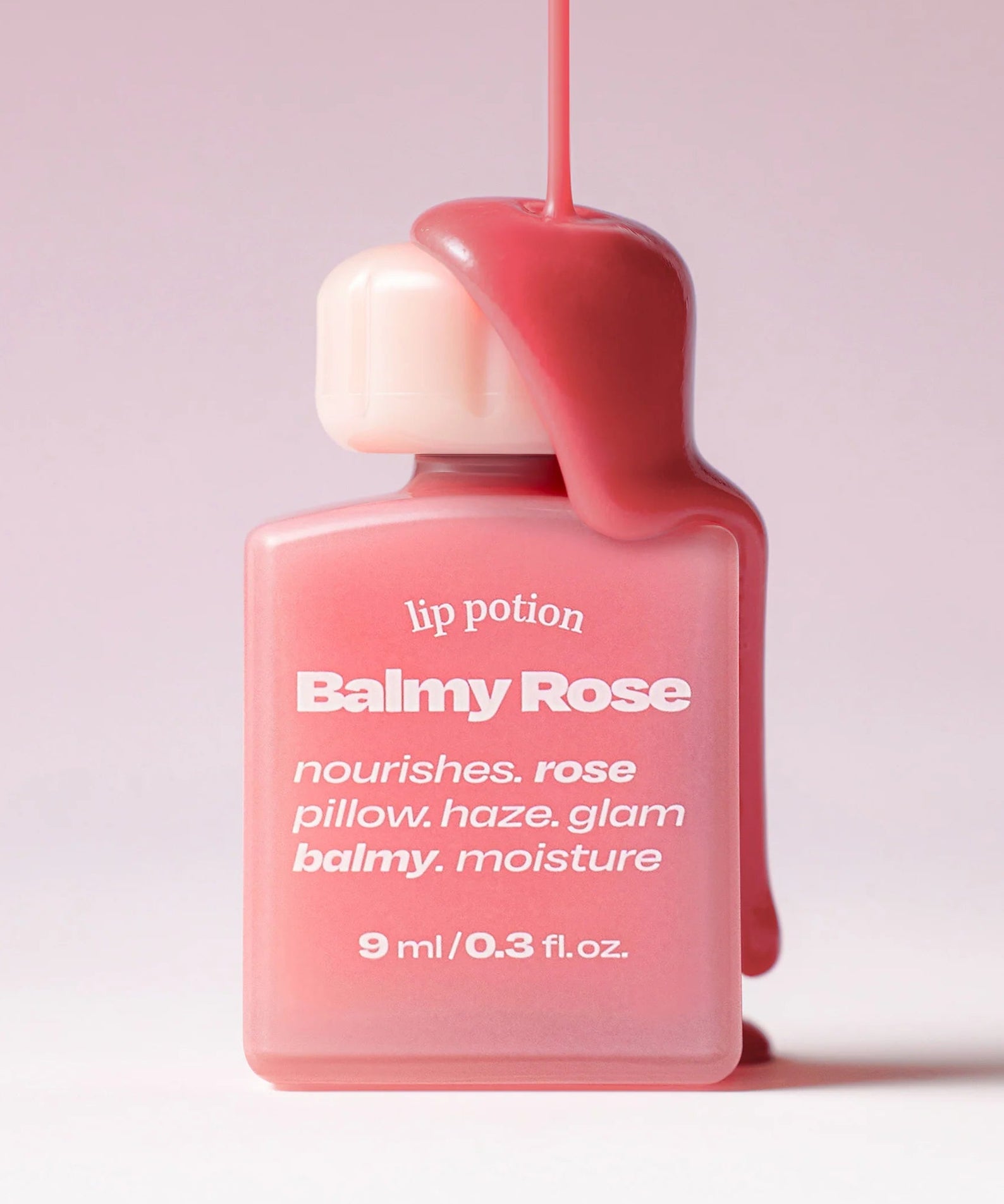 ALTERNATIVE STEREO Lip Potion Balmy Rose de la marque Alternative Stereo, flacon rouge sur fond rose, gros plan.