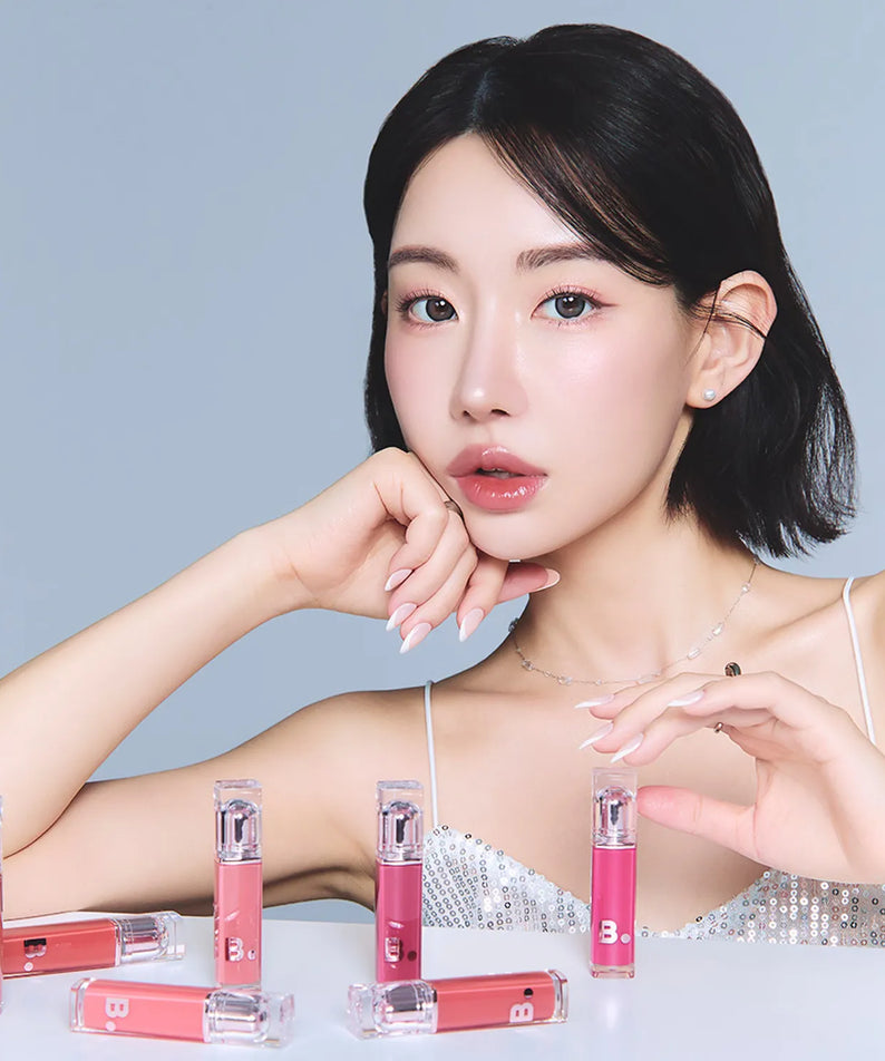 Femme posant avec BANILA CO Dew Glow Tint, rouge à lèvres hydratant tendance en plusieurs teintes élégantes.