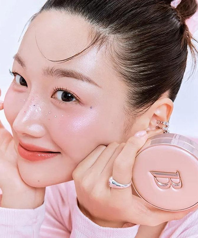 BANILA CO Essence Skin Pink Cushion de Banila Co, sur un visage maquillé, éponge/poudre rose en contexte beauté.