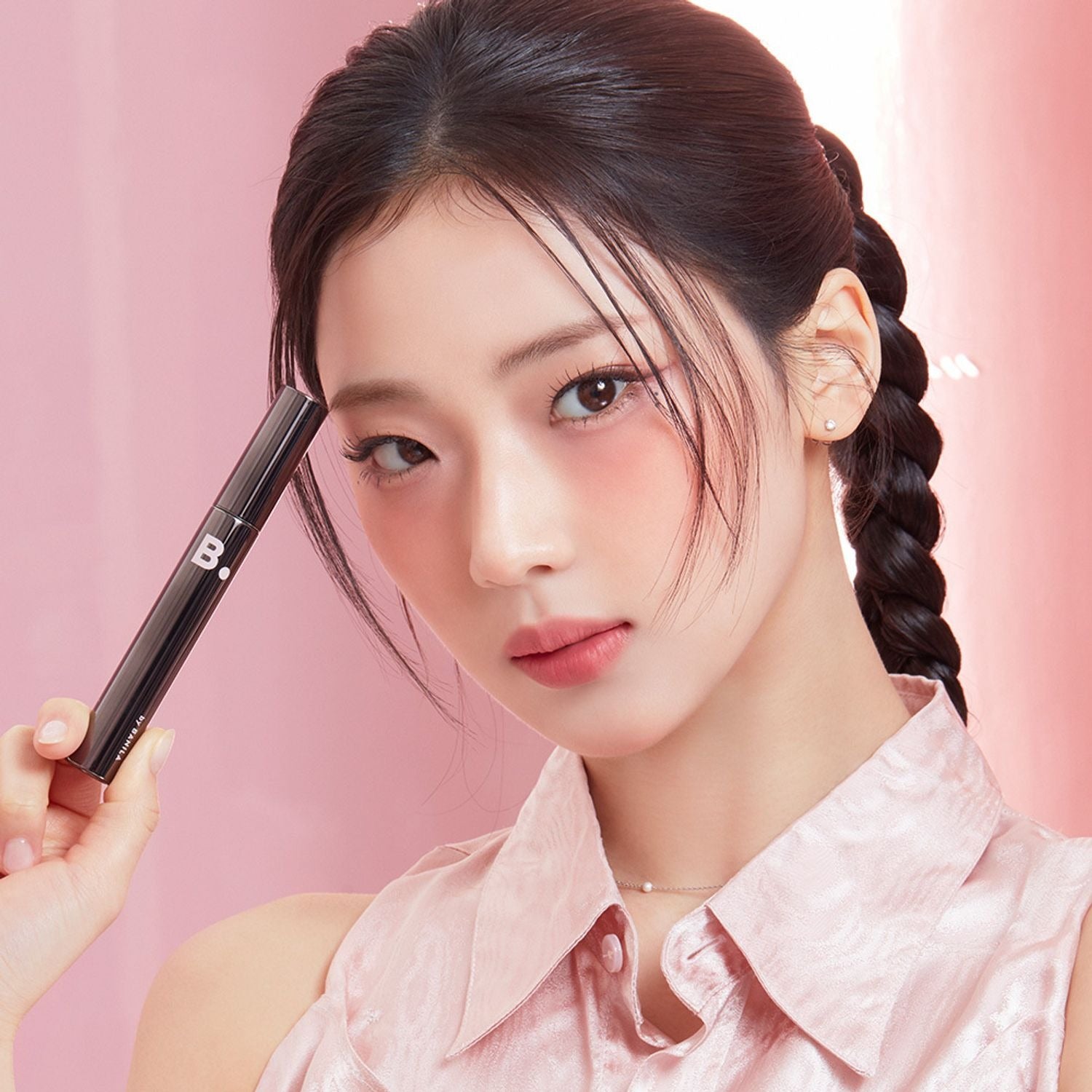 BANILA CO Powerproof Mascara de BANILACO : maquillage des yeux, mascara tenu près du visage sur fond rose.