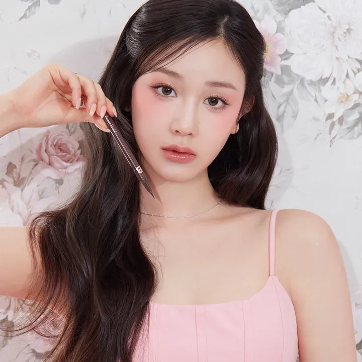 BANILA CO Powerproof Pen Eyeliner : application du liner par une femme, maquillage yeux, décor floral clair.