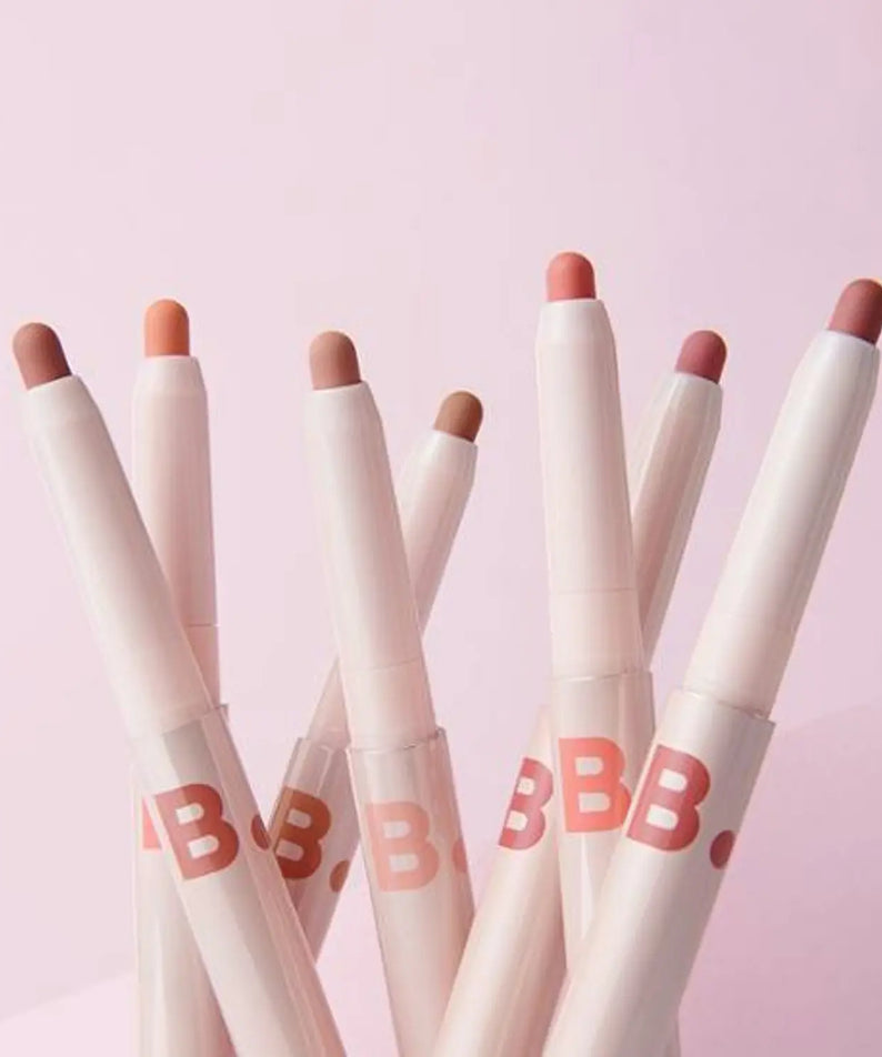 Ensemble de crayons à lèvres BANILA CO Smudging Lip Pencil sur fond rose.