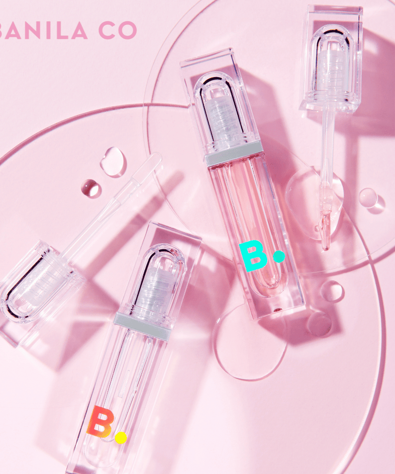 BANILA CO Volume Lip Plumper sur fond rose avec trois tubes de gloss transparent pour un effet volumateur irrésistible.
