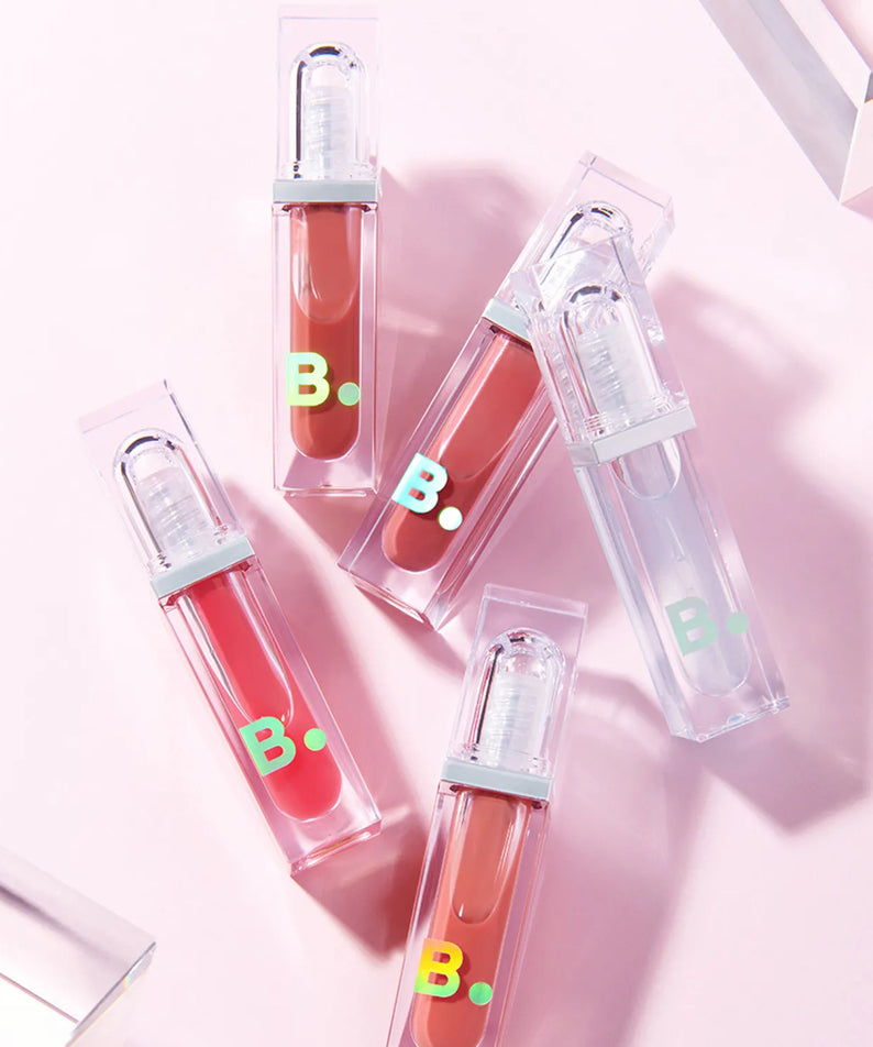 Collection de BANILA CO Volume Lip Plumper, brillants de lèvres pour volume naturel, mis en valeur sur fond rose pâle.