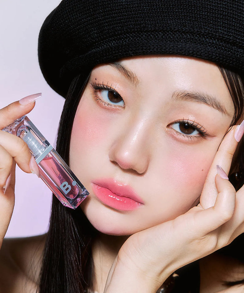 Femme appliquant le BANILA CO Volume Lip Plumper pour des lèvres pulpeuses et brillantes.