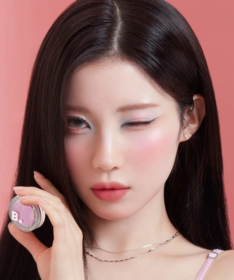 Femme utilisant le BANILACO Hyper Holobeam Eye Glitter en rose pour un look étincelant et glamour, maquillage des yeux éclatant.