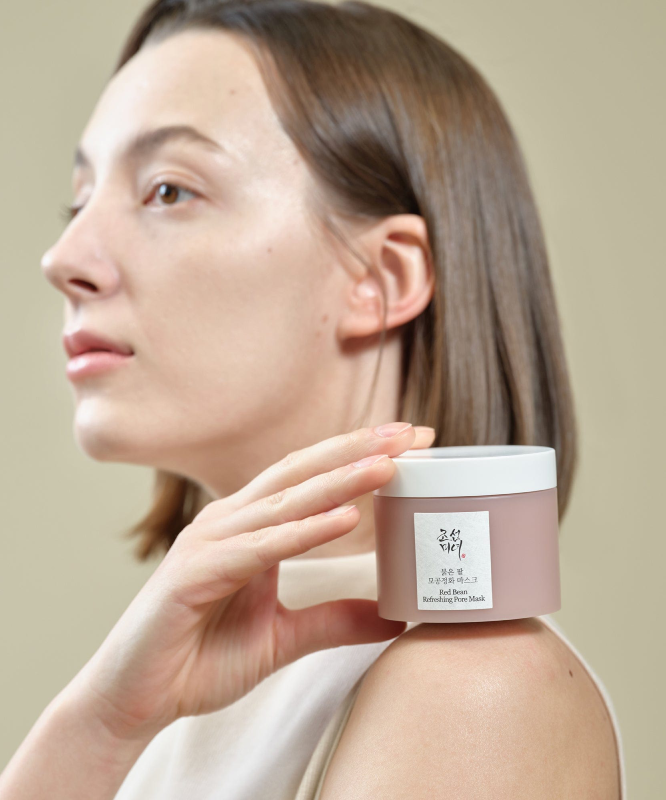 BEAUTY OF JOSEON Red Bean Refreshing Pore Mask 140ml : femme applique le masque sur le visage, pot blanc sur fond clair