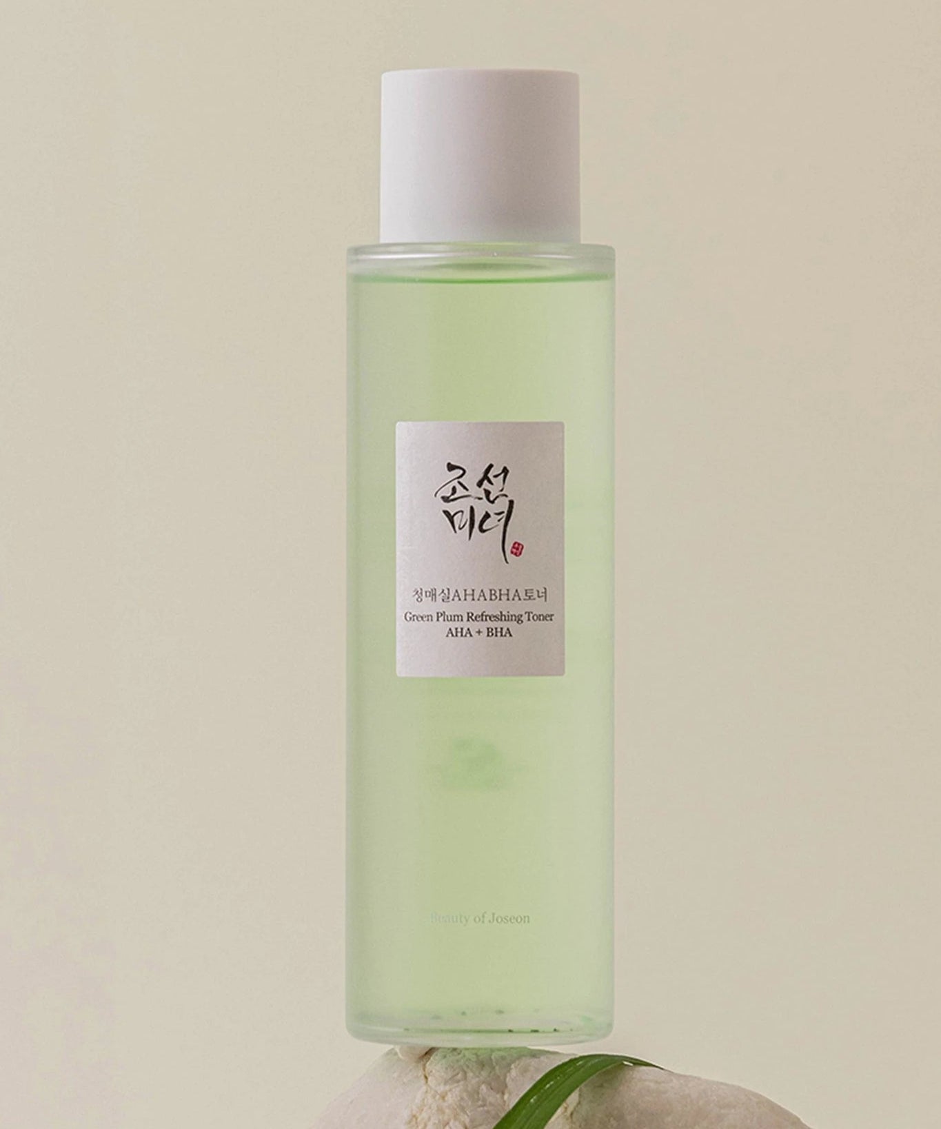 BEAUTY OF JOSEON Green Plum Refreshing Toner AHA + BHA 150ml, flacon élégant de toner purifiant et exfoliant en arrière-plan subtil.